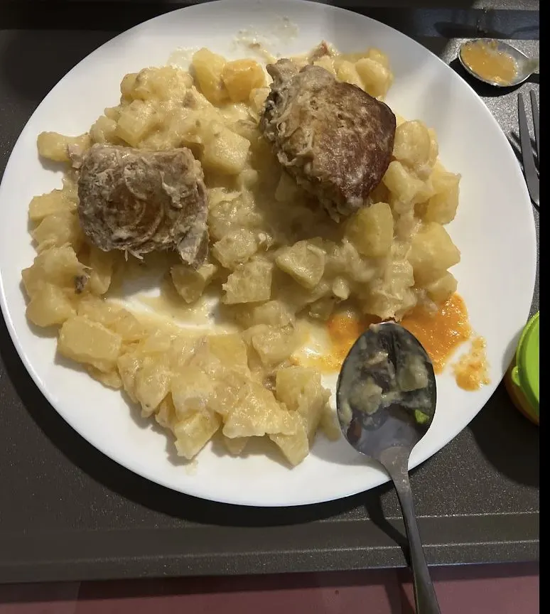 Assiette de manioc au lait de coco avec deux morceaux de poulet.